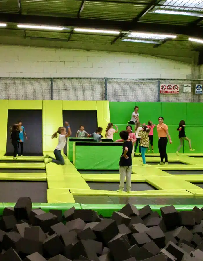 Enfants sautant sur les trampolines au bord de la fosse à mousse du parc
