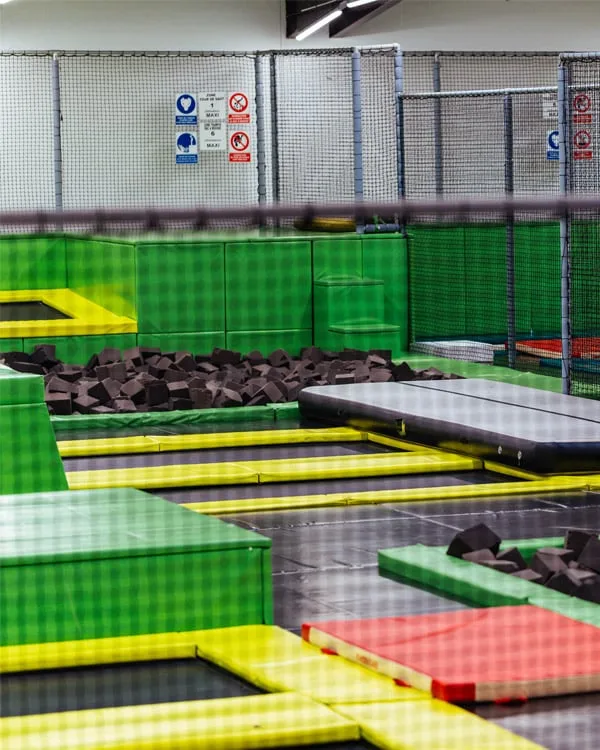 Vue d’ensemble des trampolines verts et de la fosse à mousse du parc
