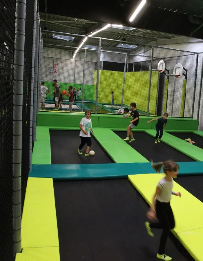 Partie de Dodgeball vue depuis le filet, terrain vert et jaune
