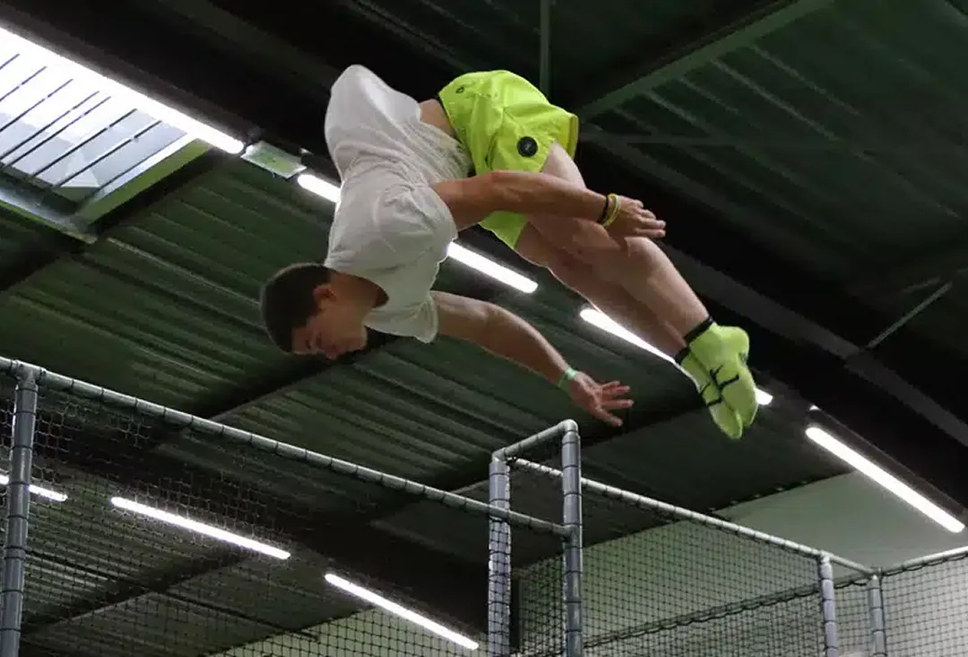 Jeune acrobate en plein saut au-dessus de la zone de trampoline