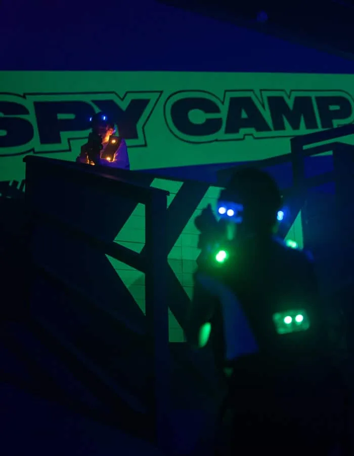 Joueurs équipés de gilets lumineux dans l’arène Spy Camp du Laser Game